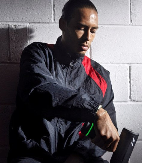 A footballer using a percussion device on his forearm
